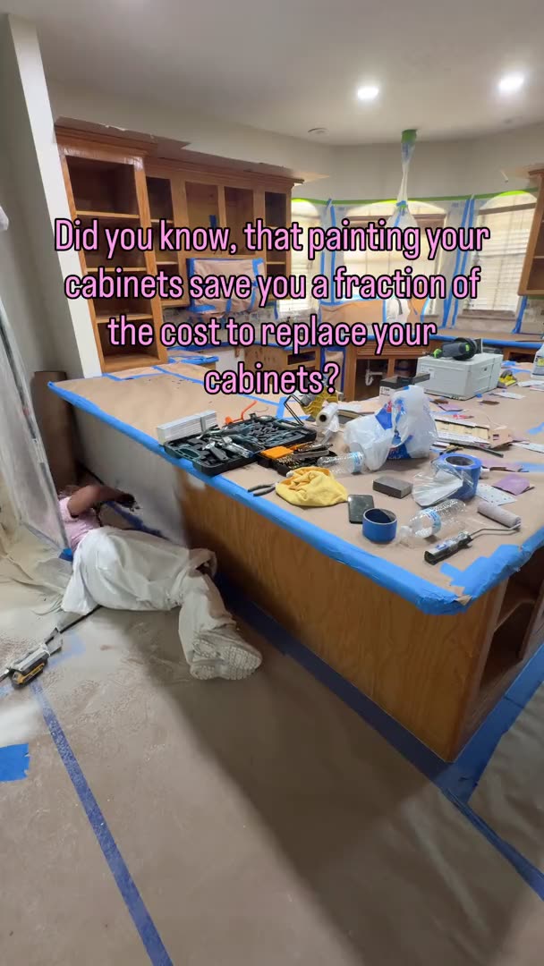 Crew prepping a wood kitchen island under tape and paper before cabinet painting in Houston, TX