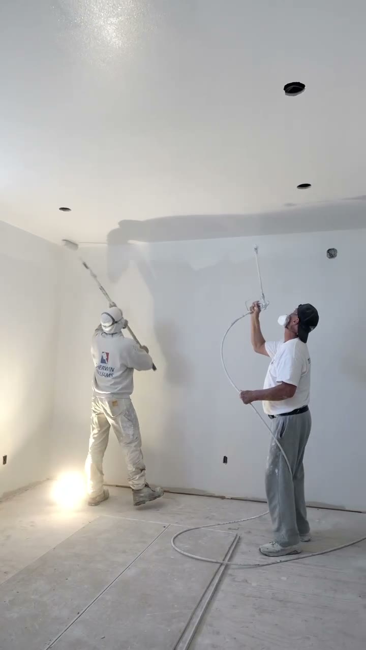 Crew spraying and back-rolling a ceiling during an interior repaint in Houston, TX